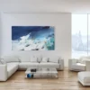 Gemälde "Thalassa" über weißem Sofa in lichtdurchflutetem Wohnzimmer mit bodentiefen Fenstern und winterlicher Aussicht